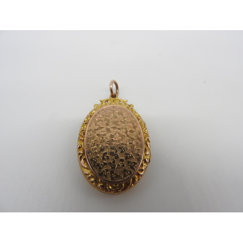 448 - A 19TH CENTURY GOLD FILLED OVAL LOCKET, with engraved profuse floral decoration and shield cartouche... 