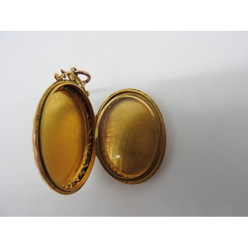 448 - A 19TH CENTURY GOLD FILLED OVAL LOCKET, with engraved profuse floral decoration and shield cartouche... 