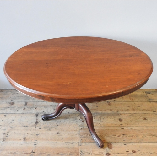 50 - A 19TH CENTURY MAHOGANY LOO TABLE, tilting oval top on a turned baluster base on three down swept sc... 
