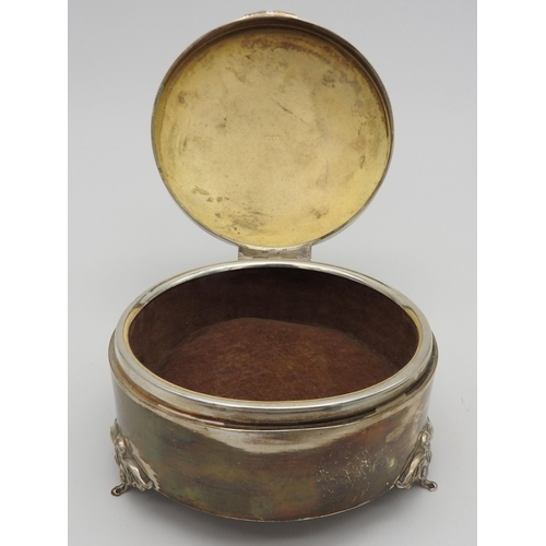 484 - A SILVER CIRCULAR RING BOX, raised on three scroll foliate feet, bears the mark William Hutton &... 