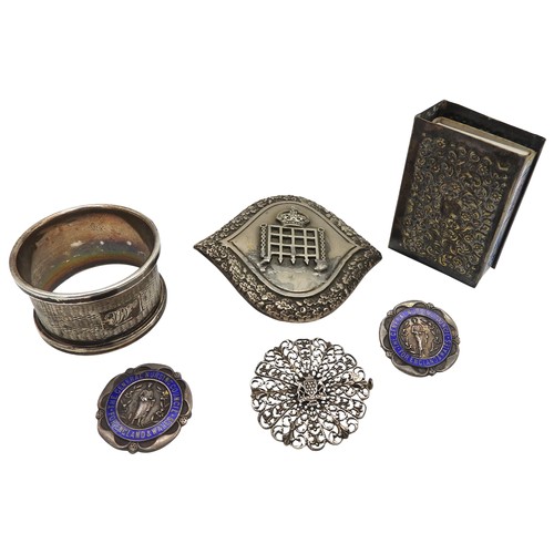 466 - A NURSE'S BELT BUCKLE, TWO ENAMELLED SILVER BROOCHES AND A SILVER NAPKIN RING, along with a filigree... 