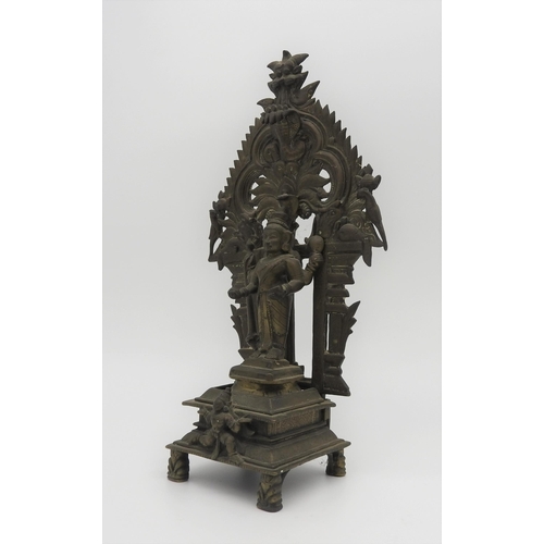 198 - A 19TH CENTURY SOUTH INDIAN BRASS SHRINE, depicting Krishna standing in front of a flaming mandala b... 