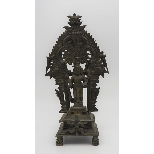 198 - A 19TH CENTURY SOUTH INDIAN BRASS SHRINE, depicting Krishna standing in front of a flaming mandala b... 