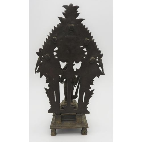 198 - A 19TH CENTURY SOUTH INDIAN BRASS SHRINE, depicting Krishna standing in front of a flaming mandala b... 