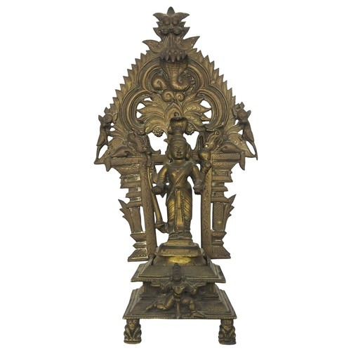 198 - A 19TH CENTURY SOUTH INDIAN BRASS SHRINE, depicting Krishna standing in front of a flaming mandala b... 