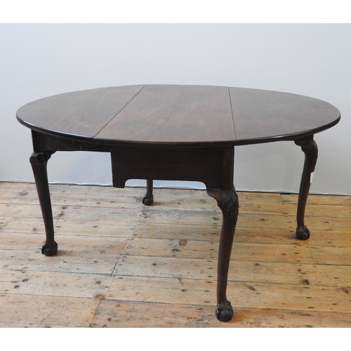 12 - A GEORGE III MAHOGANY GATE-LEG TABLE, oval top with two drop leaves, on four Acanthus carved Queen A... 