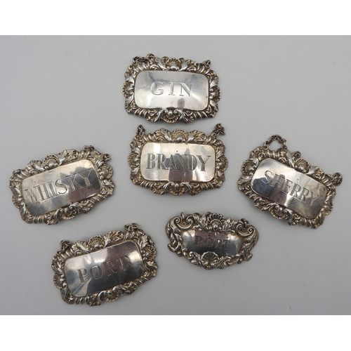 475 - A SET OF FOUR SILVER DECANTER LABELS AND TWO OTHER DECANTER LABELS, all with repousse rococo style b... 