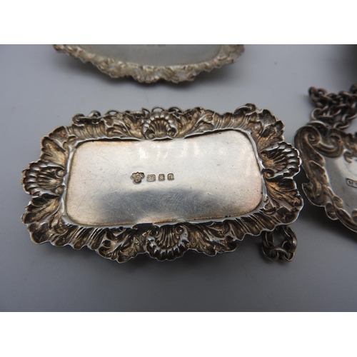 475 - A SET OF FOUR SILVER DECANTER LABELS AND TWO OTHER DECANTER LABELS, all with repousse rococo style b... 