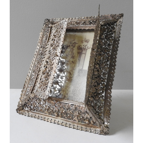 526 - INDIAN SILVER PICTURE FRAMEEARLY 20TH CENTURYof cushion-form, the sides ornately pierced with scroll... 