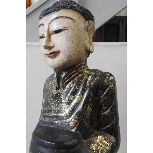 315 - A PAINTED WOODEN FIGURE OF BUDDHIST MONK, 20th century, the figure carrying a vessel with gilt paint... 