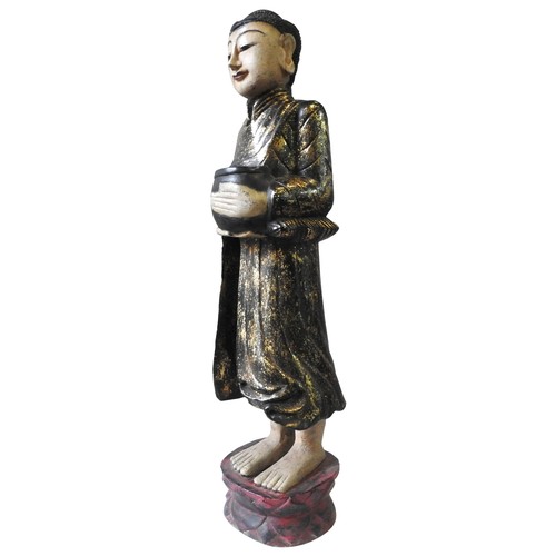 315 - A PAINTED WOODEN FIGURE OF BUDDHIST MONK, 20th century, the figure carrying a vessel with gilt paint... 