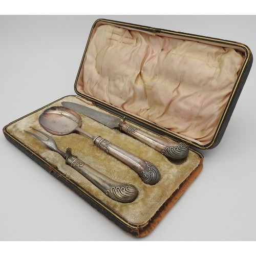 476 - A VINTAGE SILVER PLATED THREE PIECE CARVING SET, with scroll decorated handles, in a presentation bo... 