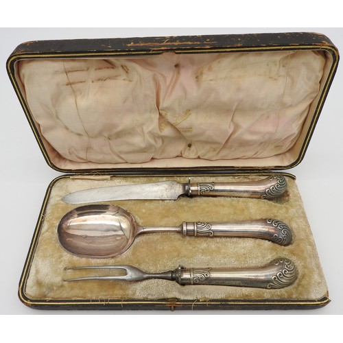 476 - A VINTAGE SILVER PLATED THREE PIECE CARVING SET, with scroll decorated handles, in a presentation bo... 