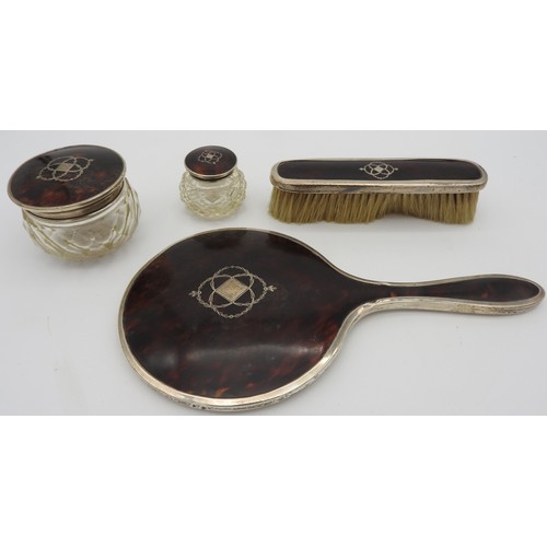 491 - A SILVER AND TORTOISESHELL MOUNTED PART VANITY SET, comprised of a vanity mirror, clothes brush and ... 