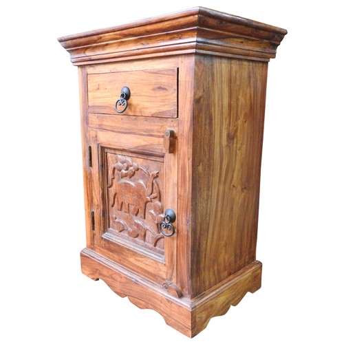 17A - A HARDWOOD BEDSIDE CUPBOARD, 20th century, single frieze drawer above a panelled door, the carved do... 