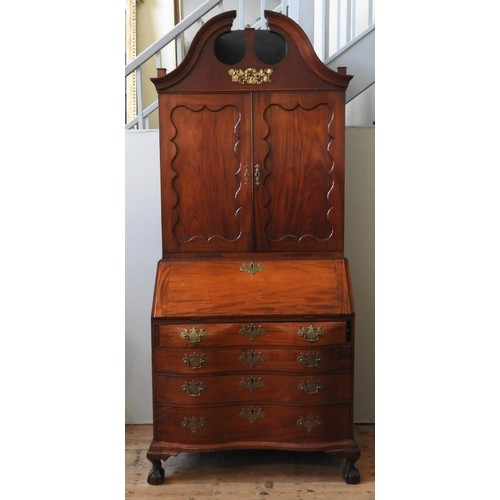 37 - AN AMERICAN MAHOGANY BUREAU BOOKCASE, two panelled doors sat atop a bombe-style bureau base with fou... 