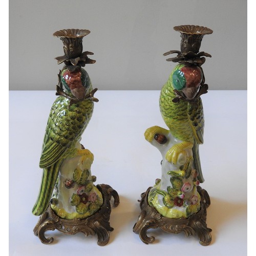 375 - A PAIR OF CERAMIC CANDLESTICKS IN THE FORM OF GREEN PARROTS, perched atop a naturalistic tree stump ... 