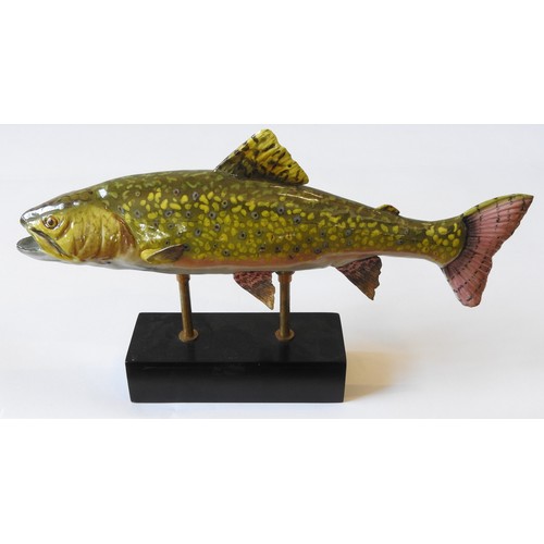 372 - A CERAMIC FIGURE OF A RAINBOW TROUT, raised on an oblong plinth base, 26.5 cm x 42 cm