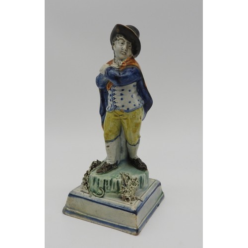 371 - A PRATT WARE FIGURE OF ROBED GENTLEMAN, early 19th century, stood on a naturalistic base raised on a... 