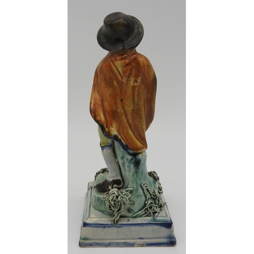 371 - A PRATT WARE FIGURE OF ROBED GENTLEMAN, early 19th century, stood on a naturalistic base raised on a... 