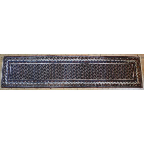 61 - A PERSIAN HAND KNOTTED RUNNER, rich blue ground with Boteh decoration454 x 109 cm