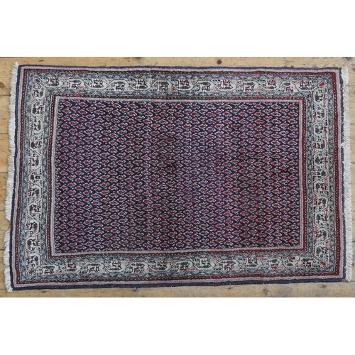 67 - A PERSIAN RUG, dark blue ground, central panel with Boteh decoration124 x 94 cm