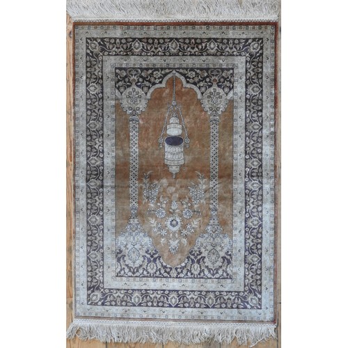 70 - A PERSIAN SILK PRAYER RUG, depiciting temple arch and lantern, on a brown ground94 x 61 cm