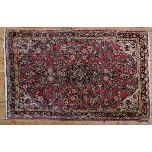 71 - A PERSIAN HAND KNOTTED RUG, floral design on a pale red ground167 x 103 cm