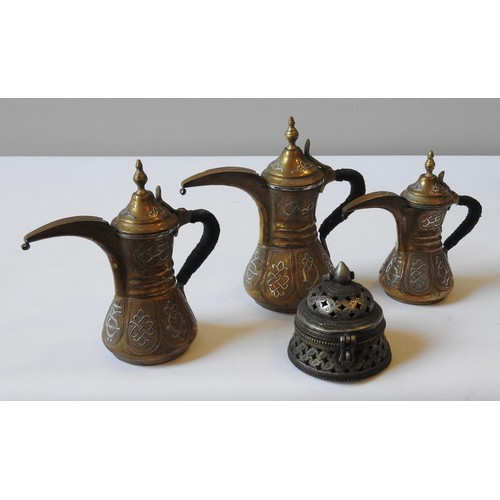 78 - THREE GRADUATED BRASS COFFEE POTS, Omani, 20th century, along with a pierced incense burner, the lar... 