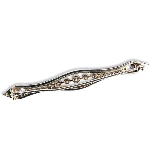 41 - A DIAMOND BAR BROOCH CIRCA 1900 set to the centre with a millegrain collet set old brilliant-cut dia... 