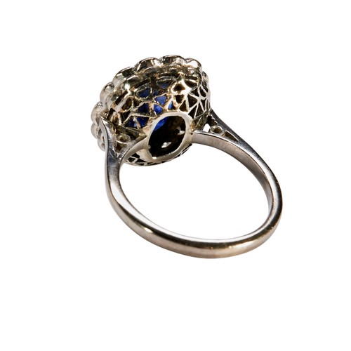 89 - A DIAMOND AND SAPPHIRE OVAL CLUSTER RINGconsisting of a central oval Sapphire in rub over setting wi... 