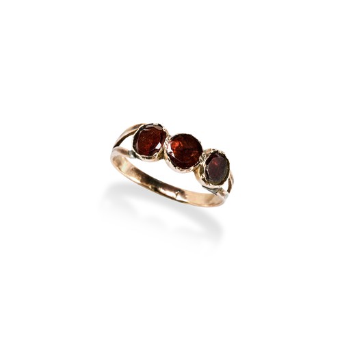 155 - A 19TH CENTURY THREE STONE GARNET RINGthe three bezel set, flat cut, garnets being foil backed betwe... 