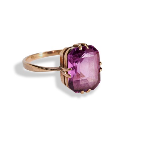 109 - A PINK SYNTHETIC SAPPHIRE RINGthe emerald-cut, cut cornered, pink synthetic sapphire being set betwe... 