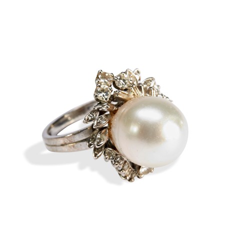 115 - A PEARL AND DIAMOND RINGset with a large central oval pearl, surrounded by a mixture of round brilli... 