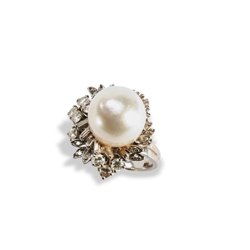 115 - A PEARL AND DIAMOND RINGset with a large central oval pearl, surrounded by a mixture of round brilli... 