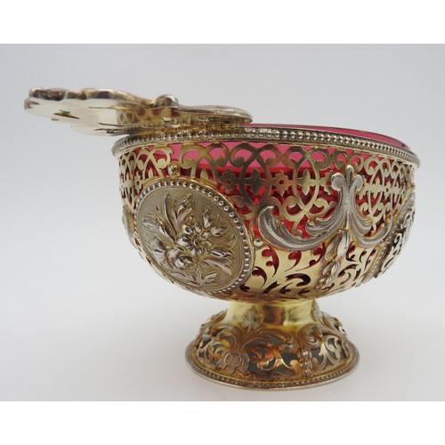 291 - AN UNUSUAL SILVER GILT OVAL BOWL, with cranberry glass liner, pierced scroll work sides emblazoned w... 