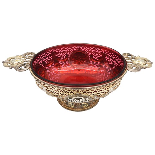 291 - AN UNUSUAL SILVER GILT OVAL BOWL, with cranberry glass liner, pierced scroll work sides emblazoned w... 