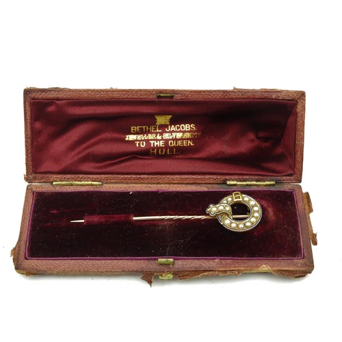 307 - A GOLD TIE PIN WITH CIRCULAR BUCKLE HEAD, inset with seed pearls, in original case