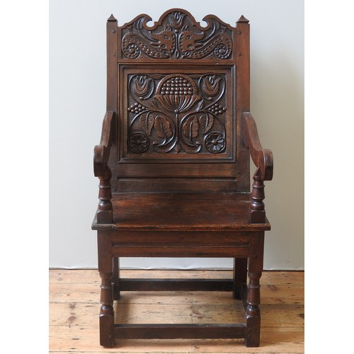 75 - AN OAK WAINSCOT CHAIRoriginating from Lancashire/ North Cheshire, the carved top rail decorated with... 