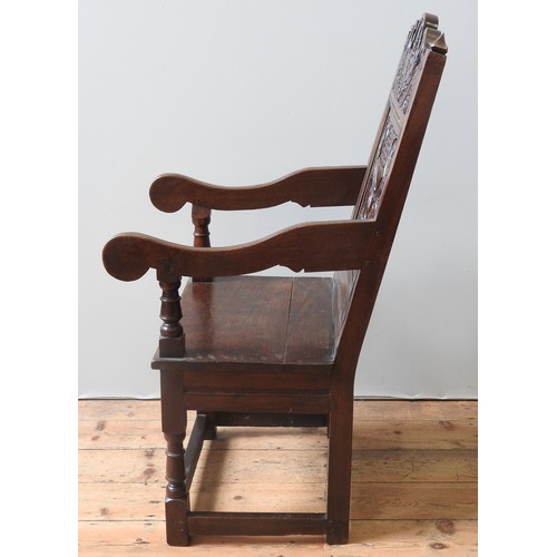 75 - AN OAK WAINSCOT CHAIRoriginating from Lancashire/ North Cheshire, the carved top rail decorated with... 