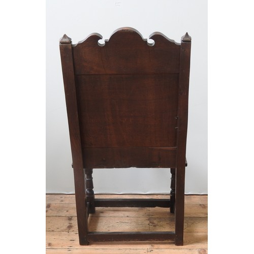 75 - AN OAK WAINSCOT CHAIRoriginating from Lancashire/ North Cheshire, the carved top rail decorated with... 