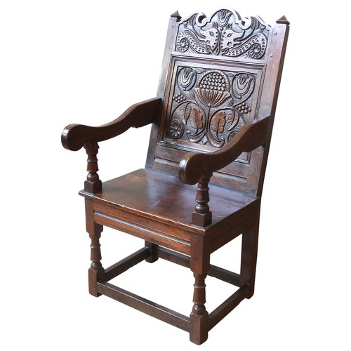 75 - AN OAK WAINSCOT CHAIRoriginating from Lancashire/ North Cheshire, the carved top rail decorated with... 