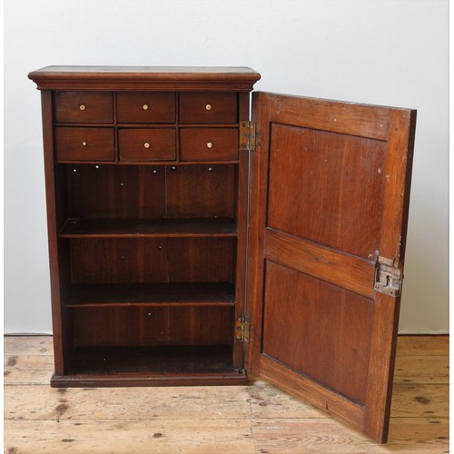 51 - AN OAK CABINET, 19TH CENTURYthe single panelled door enclosing two shelves and six small drawers, wi... 