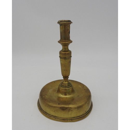 107 - AN 17TH CENTURY CONTINENTAL BRASS CANDLESTICK, probably Dutch, on a distinctive bell shape base21 cm... 