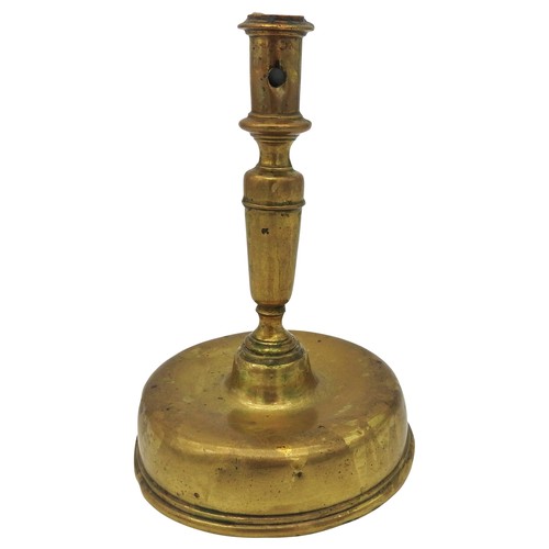 107 - AN 17TH CENTURY CONTINENTAL BRASS CANDLESTICK, probably Dutch, on a distinctive bell shape base21 cm... 