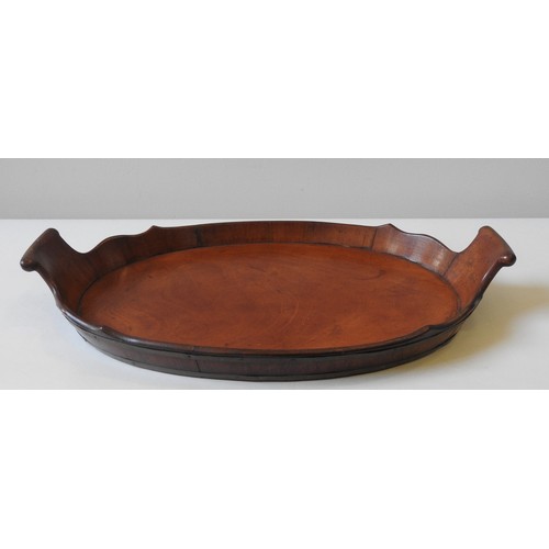 67 - A GEORGE III MAHOGANY COOPERED TRAY, oval form with two scroll handles and shaped gallery edge63 x 3... 