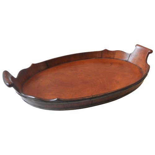 67 - A GEORGE III MAHOGANY COOPERED TRAY, oval form with two scroll handles and shaped gallery edge63 x 3... 