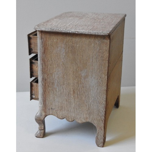 66 - A LIMED OAK MINIATURE CHEST OF DRAWERS, LATE 19TH/EARLY 20TH CENTURY, moulded edge top above three d... 