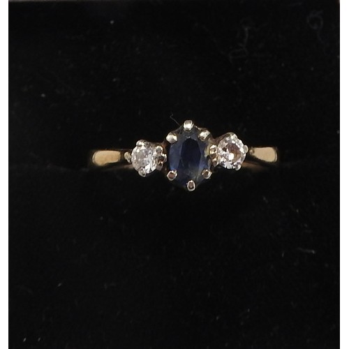 298 - A SAPPHIRE AND DIAMOND SET GOLD RING, set with a central oval sapphire flanked by two brilliant cut ... 