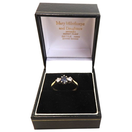 298 - A SAPPHIRE AND DIAMOND SET GOLD RING, set with a central oval sapphire flanked by two brilliant cut ... 